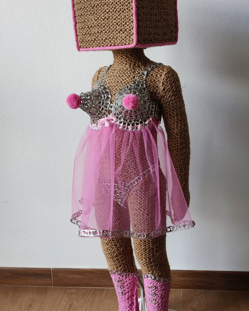 Sculptural work titled Hi, they call me Honey Pie by contemporary artist Nanon Morsink, made from rope, can tabs, tulle, thread, wool, and a doll.
