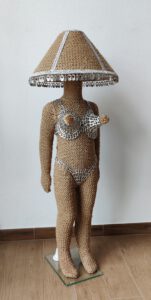 Sculptural work (working lamp) titled Hi, they call me Candy (Candy lamp) by contemporary artist Nanon Morsink, made from rope, can tabs, a lamp shade, and a doll.
