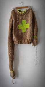 Sculptural work titled Sometimes life sucks by contemporary artist Nanon Morsink, made from rope, wool, hands, and wooden knitting needles.