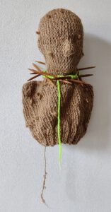 Sculptural work titled Artificial head by contemporary artist Nanon Morsink, made from rope, wool, wooden knitting needles, and a head.