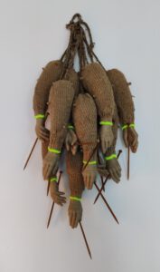 Contemporary art piece by Nanon Morsink titled "Cuídate (take care of yourself)", made with rope, wooden knitting needles, wool, and hands.