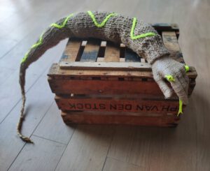 Sculptural work titled Protect me from what I want by contemporary artist Nanon Morsink, made from rope, neon wool, cord, and a hand.