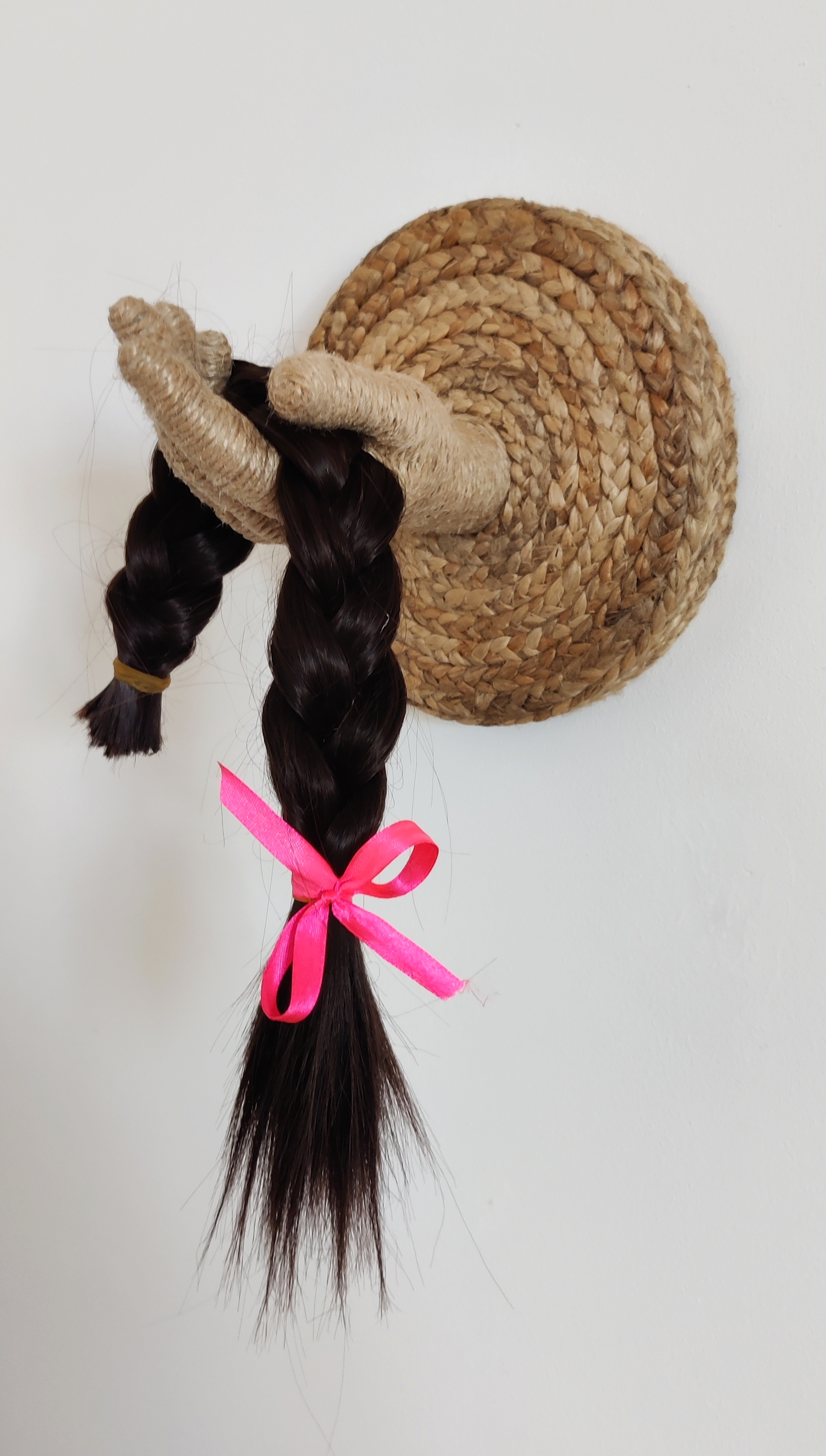 Contemporary artwork by Nanon Morsink titled The Sacrifice, made with jute cord, rope, hand, MDF, hair, and ribbon