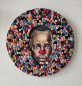 Soft sculpture ‘I Am Funny’ by Nanon Morsink (2025). Contemporary textile art with wool, acrylic paint, and pompons – round wall piece.