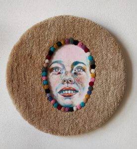 Contemporary textile wall sculpture titled “I Am Happy” by Nanon Morsink, part of the Soft Series. Mixed media with tufted wool, pompons, and acrylic paint on board, 50 cm diameter, 2025. Colorful circular fiber art.