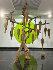 Contemporary tree sculpture with rope, hands, and apple – “Lost Paradise” by contemporary artist Nanon Morsink